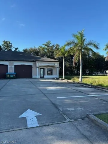 View of car parking featuring concrete driveway and a garage