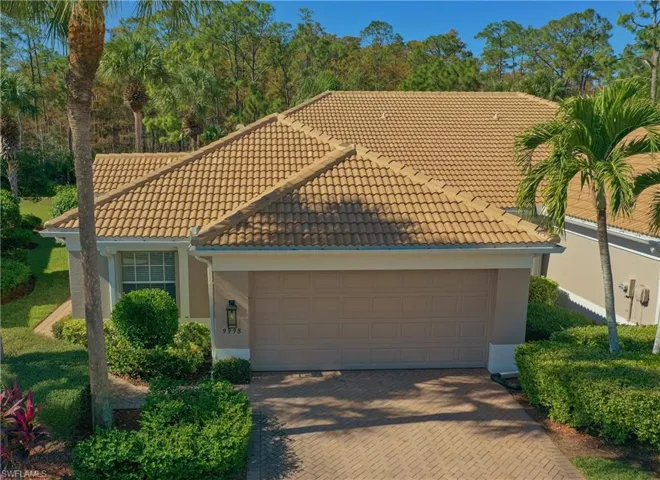 Mediterranean / spanish-style home with a tile roof, stucco siding, decorative driveway, and a garage