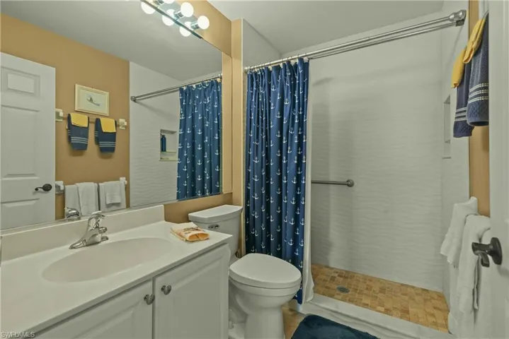 Bathroom with vanity and tiled shower