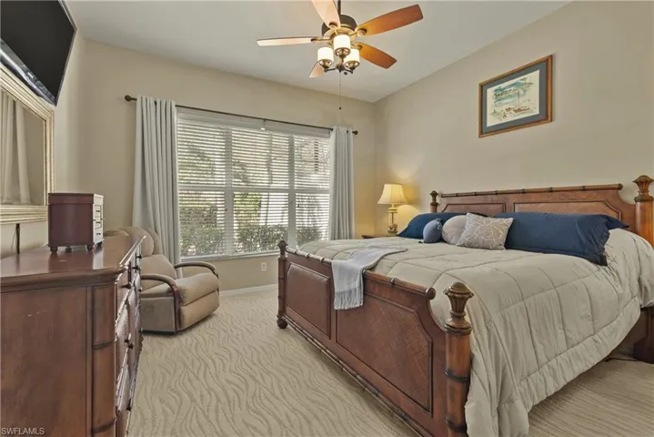 Bedroom with ceiling fan and light colored carpet