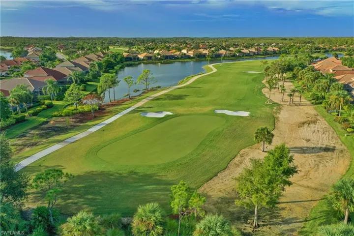 Aerial view of residential area with a nearby body of water and a local golf course