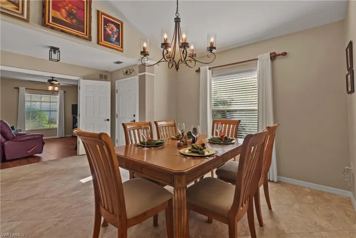 Dining area with a chandelier, vaulted ceiling, and a ceiling fan