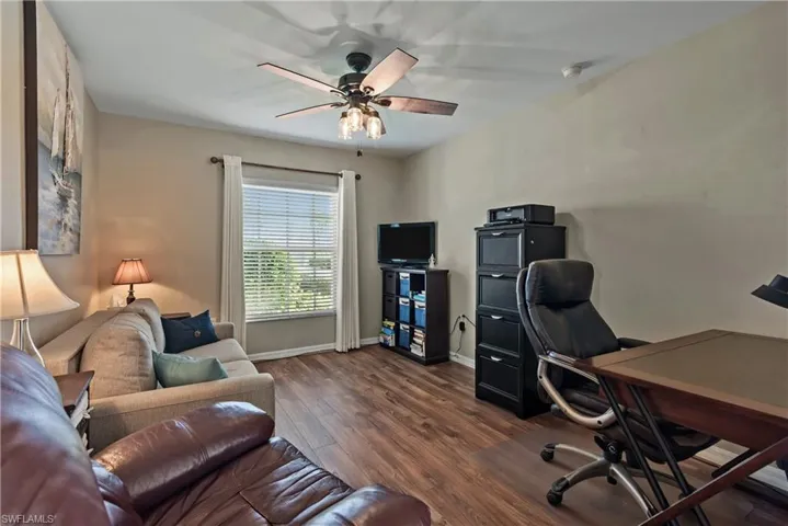 Home office featuring dark wood-style floors and ceiling fan