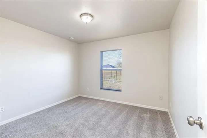 Empty room with carpet flooring and baseboards