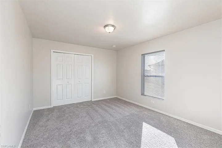 Unfurnished bedroom with carpet and a closet