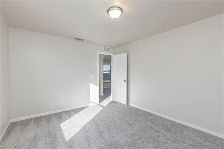 Carpeted empty room featuring baseboards