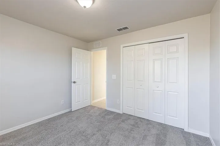 Unfurnished bedroom featuring carpet floors and a closet