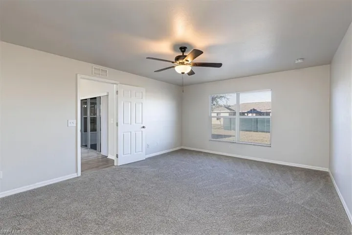 Spare room featuring carpet flooring and ceiling fan