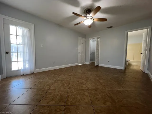 Unfurnished bedroom featuring a ceiling fan and dark tile patterned flooring