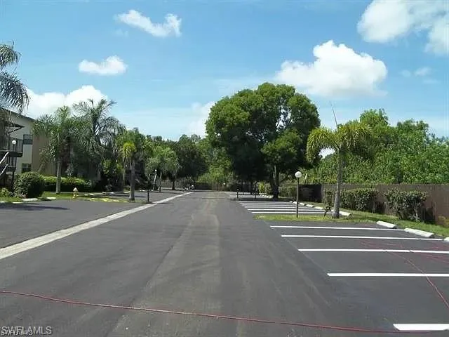 View of asphalt road featuring street lights