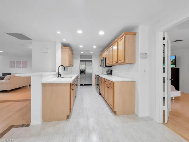 Kitchen featuring stainless steel appliances, brand new quartz countertops, sink, and custom cabinetry