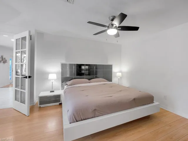 Bedroom featuring ceiling fan, wood-type flooring, and french doors