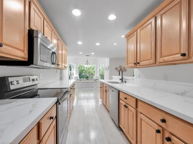 Kitchen featuring stainless steel appliances, brand new quartz countertops, sink, and custom cabinetry