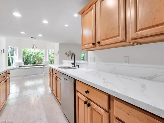 Kitchen featuring stainless steel appliances, brand new quartz countertops, sink, and custom cabinetry