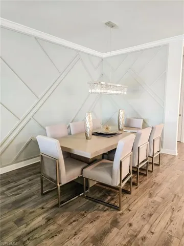 Dining space featuring wood finished floors and a decorative wall