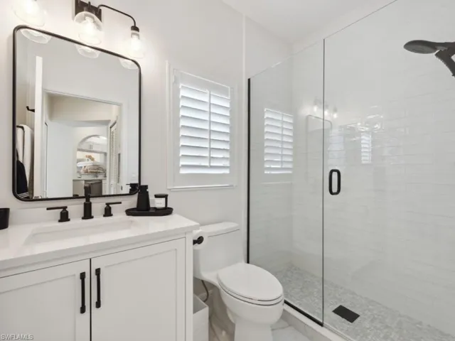 Guest Bathroom Recently Renovated featuring vanity, toilet, and an enclosed shower