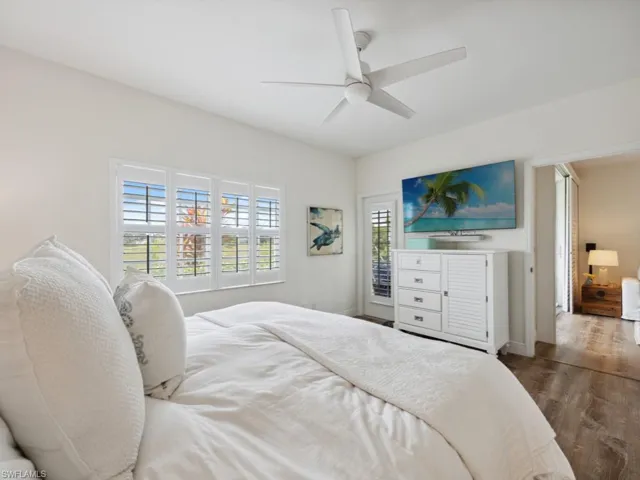 Primary Bedroom with multiple windows, wood-style flooring, and ceiling fan