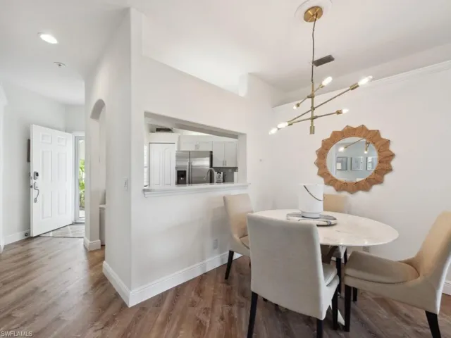 Dining area with wood-style flooring and a custom chandelier