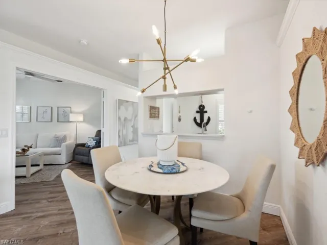 Dining area with wood-style flooring and a custom chandelier