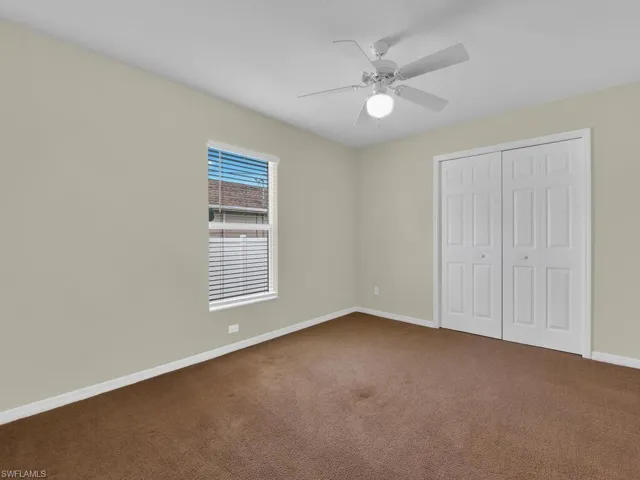 Unfurnished bedroom with carpet flooring, a closet, and a ceiling fan
