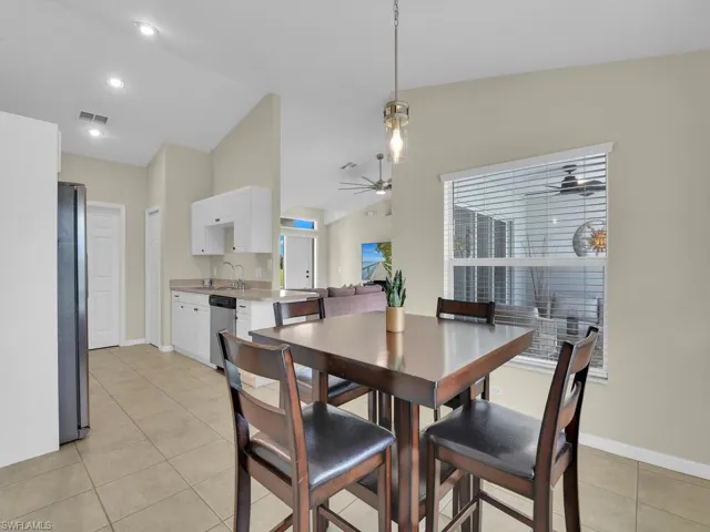 Dining room featuring light tile patterned floors, lofted ceiling, and recessed lighting