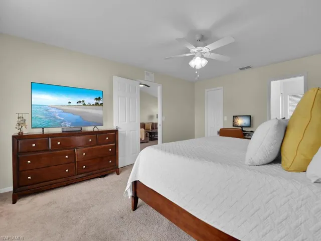 Bedroom featuring light carpet, ceiling fan, and a closet