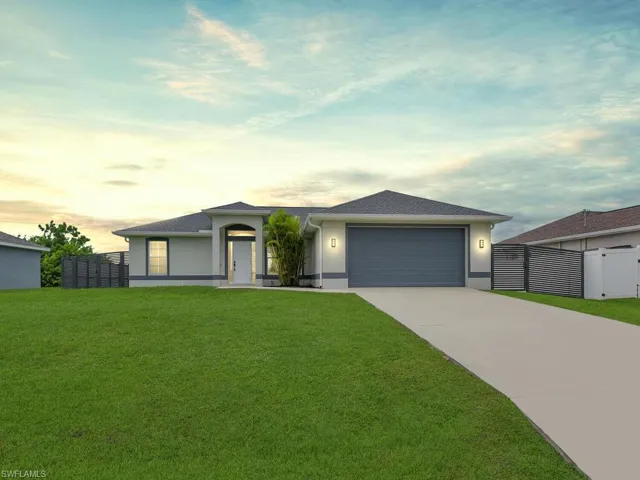 View of front of house featuring stucco siding, driveway, and a garage