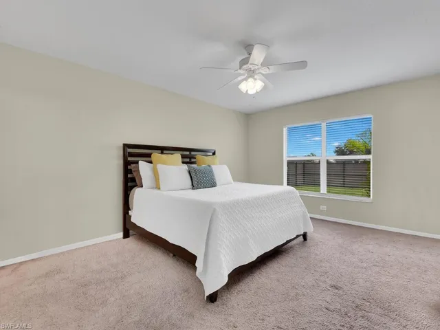 Carpeted bedroom with baseboards and ceiling fan
