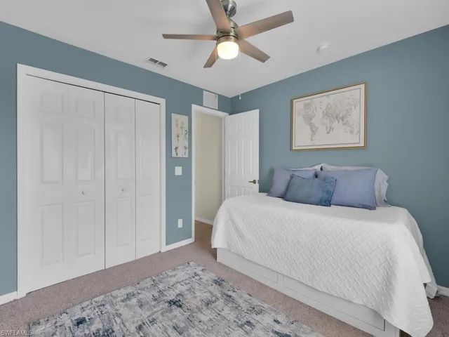 Bedroom featuring carpet, ceiling fan, and a closet