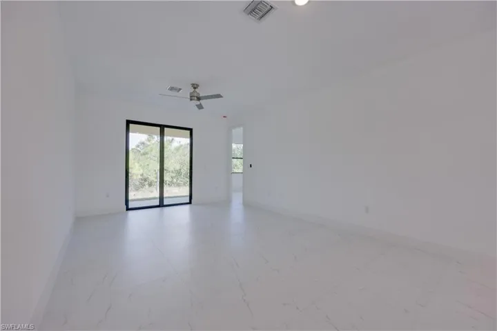 Spare room with light marble finish flooring and ceiling fan