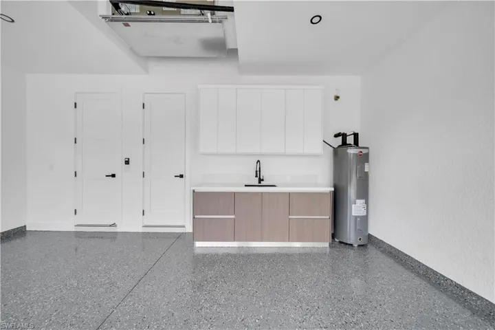 Garage with electric water heater and a sink