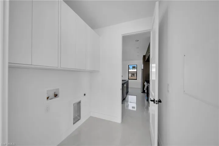 Laundry area featuring washer hookup, hookup for an electric dryer, finished concrete floors, and cabinet space