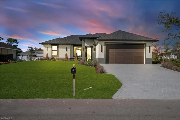 Prairie-style house featuring stucco siding, an attached garage, and driveway