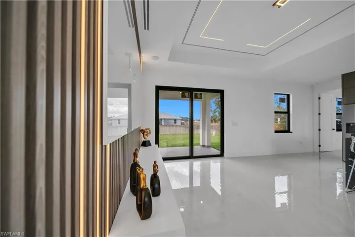 Unfurnished room featuring a raised ceiling and healthy amount of natural light