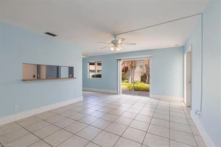 Living room with view out sliding glass door to side patio