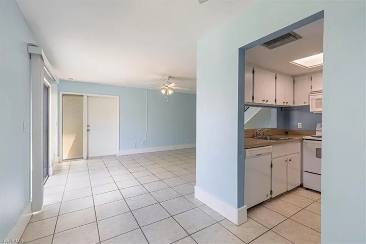 View of kitchen into living space and front door.