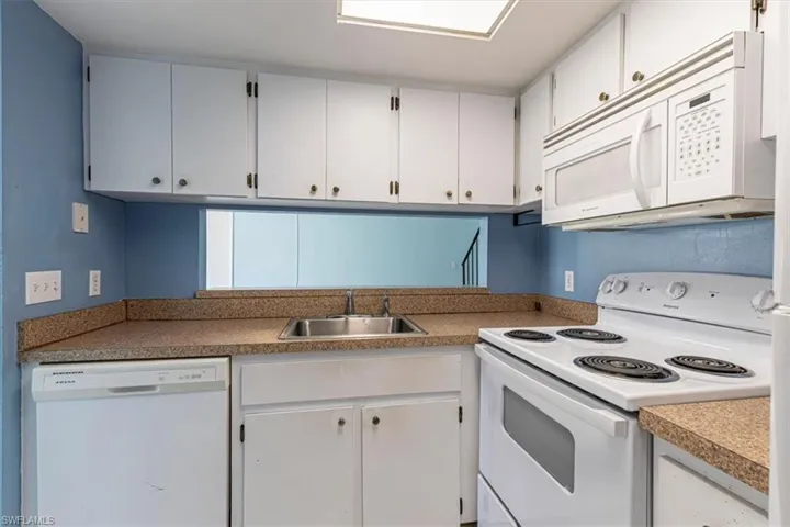 Kitchen with opening to living room. View when you walk from garage into the unit