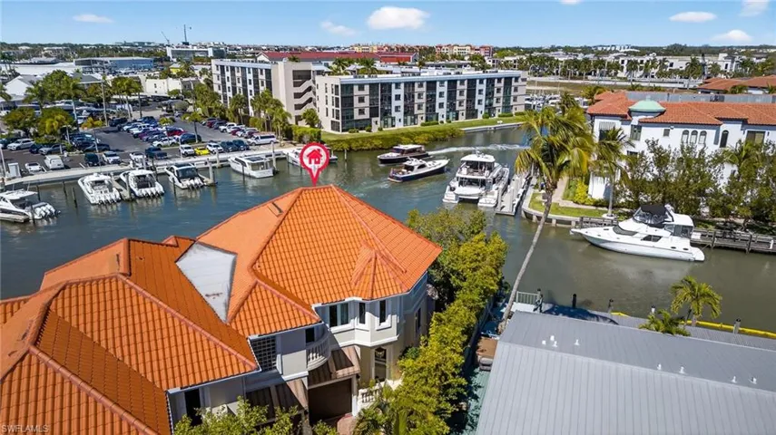 Drone / aerial view of a nearby body of water and apartment complex / building