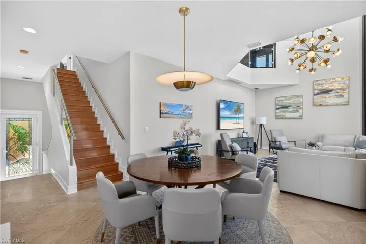 Dining area with hanging lights and light stone finish flooring
