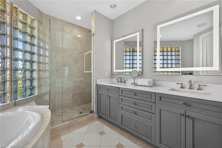Bathroom featuring double vanity, a stall shower, light tile patterned flooring, a bath, and recessed lighting