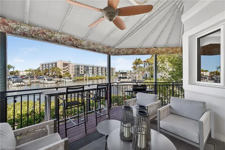 Balcony featuring a ceiling fan, outdoor seating, and a water view