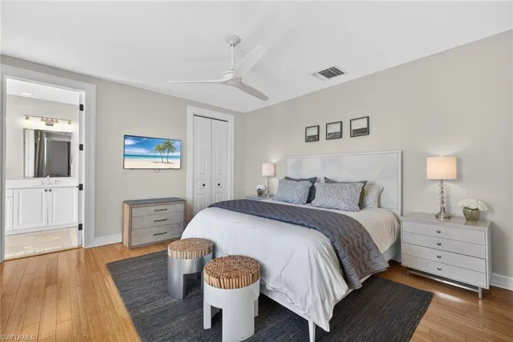 Bedroom with light wood-style floors, a ceiling fan, a closet, and ensuite bathroom
