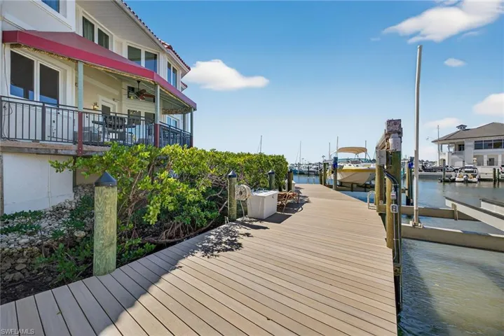 Dock area with a water view, boat lift, and covered porch