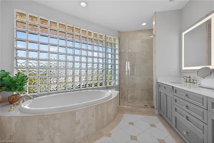 Full bathroom with vanity, a stall shower, light tile patterned floors, a bath, and recessed lighting