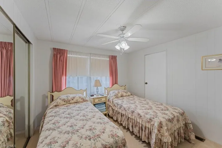 Bedroom featuring light carpet, a textured ceiling, a closet, and ceiling fan