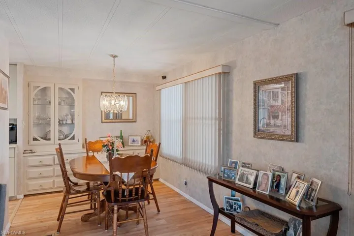 Dining room featuring a textured ceiling, light wood-type flooring, and a notable chandelier