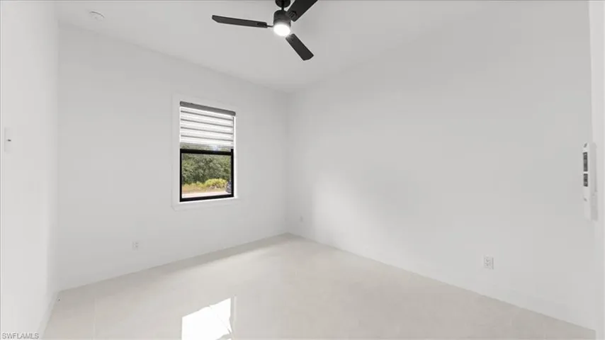 Unfurnished room featuring ceiling fan and baseboards
