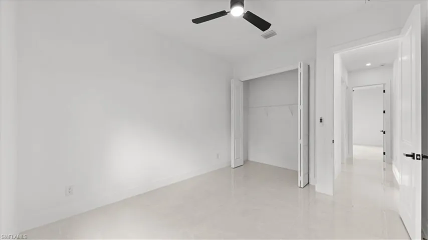 Unfurnished bedroom with a closet, ceiling fan, and light tile patterned flooring