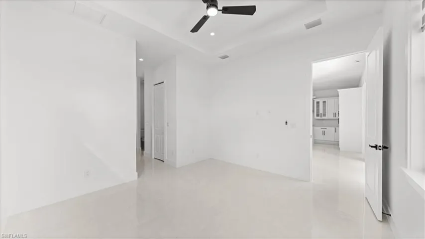 Unfurnished bedroom with a raised ceiling, a ceiling fan, and recessed lighting