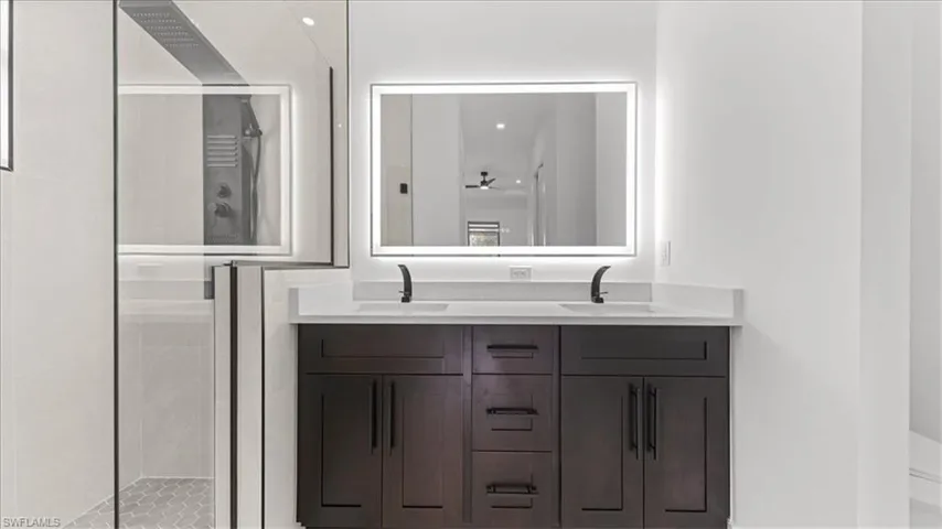 Bathroom featuring double vanity, a stall shower, and recessed lighting